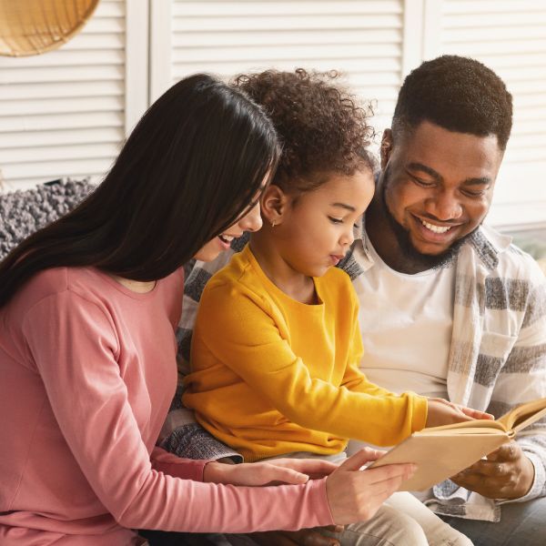 parents reading book to child